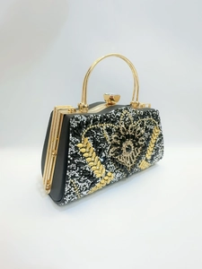 Détail de la pochette de soirée à strass avec motifs de feuilles dorées