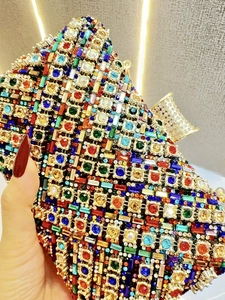 Detail einer Luxus-Clutch mit bunten Kristallen und goldfarbenen Metallelementen