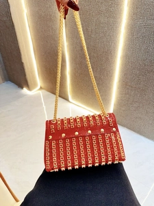 Detail of red rhinestone clutch bag with gold chain strap for wedding and evening galas