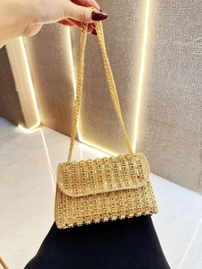 Detail of gold evening clutch bag with square yellow crystals and metal chain strap