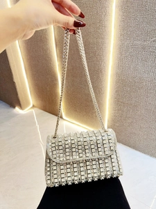 Detailed view of silver evening bag with sparkling crystals and metal chain strap