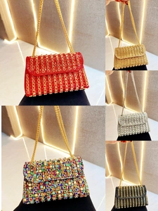 Detail of luxury rhinestone clutch bags in red gold and silver with metal chain straps