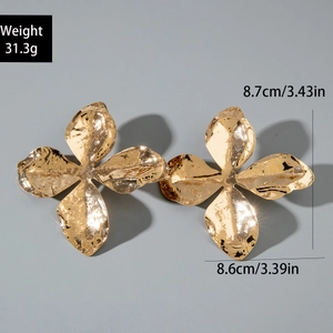 Detail view of large gold flower earrings showing hammered metal texture and dimensions