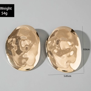 Detail view of large gold-tone irregular textured earrings with size measurements