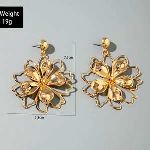 Detail view of large gold hollow flower earrings with size and weight measurements