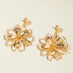 Close-up of golden layered flower earrings with glossy petals and geometric design