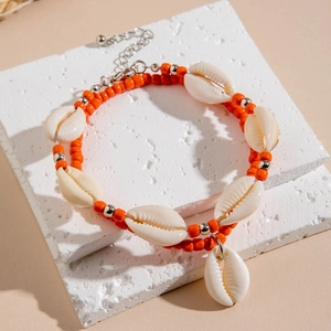 Détail de la chevillère bohème à double couche de perles orange avec coquillages naturels