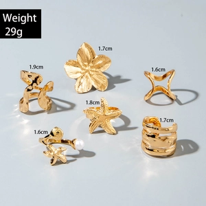 Détails d'un ensemble de bagues bohèmes dorées avec fleurs, coquillages et perles