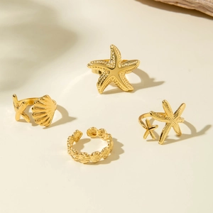 Ensemble de bagues bohèmes dorées sur le thème océan avec étoiles de mer et coquillages