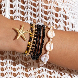 Bohemian multi-layer beaded bracelet with golden starfish charm and cowrie shell detail