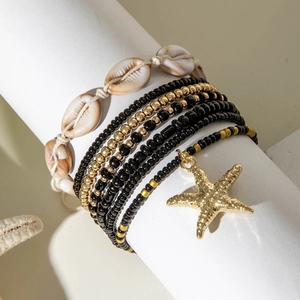 Close-up of bohemian starfish and seashell beaded bracelets with gold accents