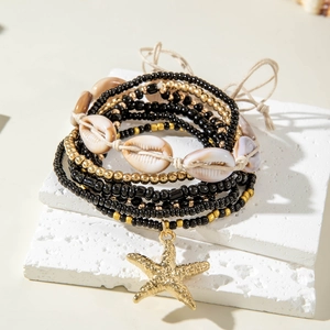 Detail of bohemian multilayer beads bracelet with starfish charm and natural shells