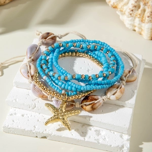 Detail of bohemian multilayer beaded bracelet with starfish charm and natural shells