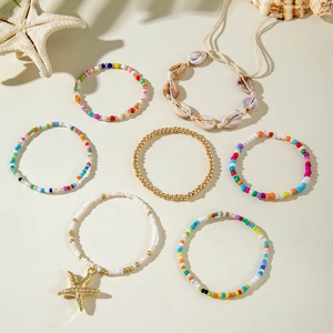 Detail of bohemian 7-piece beach anklet set featuring colorful beads and starfish pendant