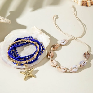 Detail of beach bracelets with blue beads, starfish charm and natural shells set