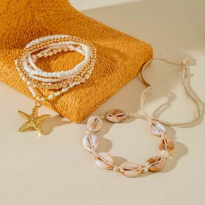 Detail of bohemian shell bracelet and gold starfish pendant with multi-layer beads
