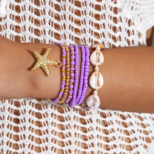 Detail of bohemian layered beads bracelet set with starfish charm and natural seashells