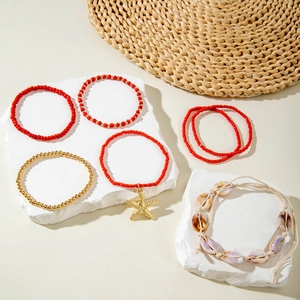 Detail of Bohemian beaded bracelet set featuring golden starfish charms and natural seashells