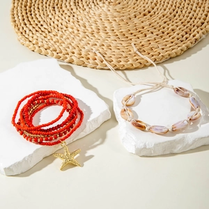Detail of bohemian red beaded bracelet with starfish charm and natural shell strand