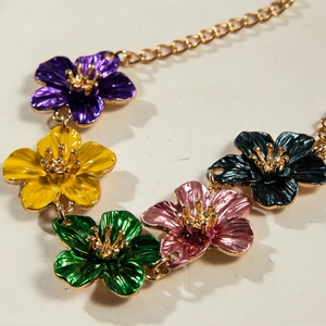 Close-up of vibrant multi-colored enamel flower pendants on a delicate gold chain