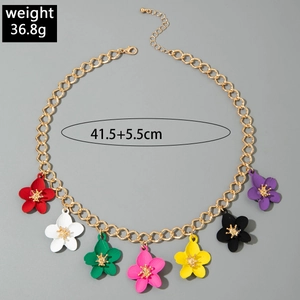 Detail view of gold chain necklace with seven multi-colored matte flower charms and golden centers
