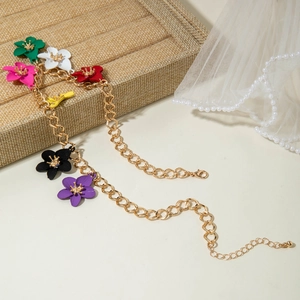 Detailed view of golden chain with colorful metal flower pendants and shell accents