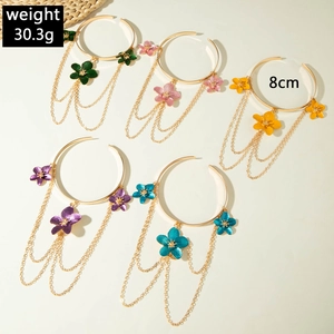 Five-piece set of gold floral bracelets with dangling metal chains and colorful enamel flowers