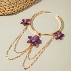 Close-up of golden necklace with purple flowers and tiered fringe chain tassels