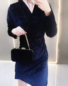 Detail of elegant black velvet evening clutch bag with gold chain and metal lock