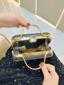 Elegant black hard shell evening clutch bag with gold frame and sparkling rhinestone details