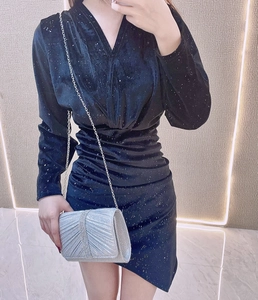 Close-up of sparkling silver rhinestone clutch bag paired with a blue velvet dress
