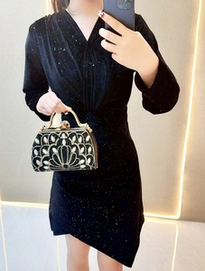 Detail of sunflower rhinestone pattern on black velvet evening bag with gold handle