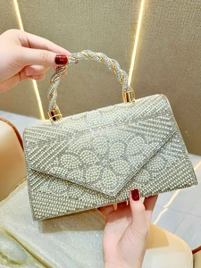 Detailed view of pearl and rhinestone floral pattern on luxury evening clutch handbag