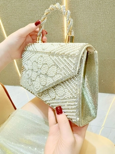 Close-up of pearl evening bag with rhinestone floral pattern and luxury crystal handle