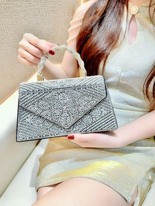 Close-up of evening clutch bag with sparkling rhinestones and twisted silver handle