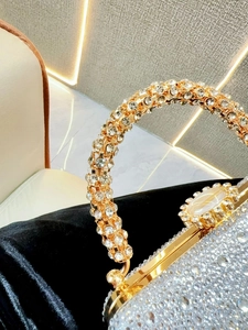 Détail de strass en cristal sur pochette de luxe avec grand fermoir gemme et cadre doré