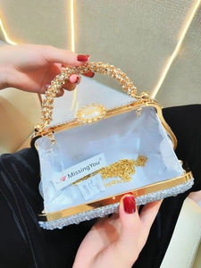 Détail d'une pochette de soirée en strass avec monture dorée et bandoulière chaîne
