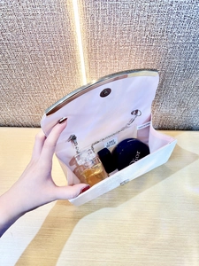 Beige silk evening clutch with chain strap showing storage space for makeup and perfume