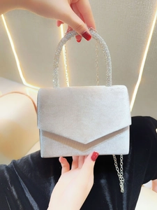Close-up of elegant silver velvet evening clutch with luxury rhinestone handle and chain
