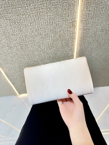 Detailed close-up of champagne silk evening clutch featuring elegant pleated ruffles