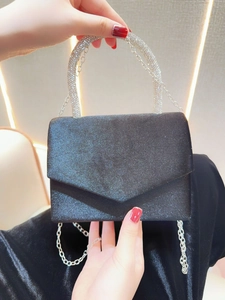Detail of black glitter evening bag with rhinestone handle and silver chain strap