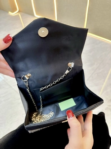 Detail of black rhinestone evening bag with silver chain strap and magnetic snap closure