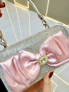 Luxury silver rhinestone evening clutch with large pink satin bow and metal ring handle