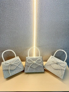 Elegant rhinestone bow evening clutch bag with trapezoid shape and top handle