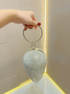 Detailed macro view of silver rhinestone evening bag with elegant fringe and ring handle