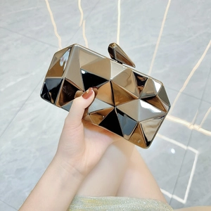 Macro detail of faceted geometric acrylic clutch bag with metallic mirror finish