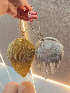 Detail of round rhinestone evening clutch bags with long crystal tassels and ring handles