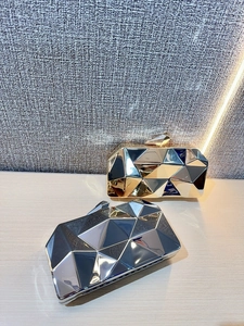 Detail of gold and silver geometric acrylic clutch bags with diamond-cut metal finish
