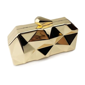 Macro view of gold geometric faceted evening clutch with polished mirror finish metal surface