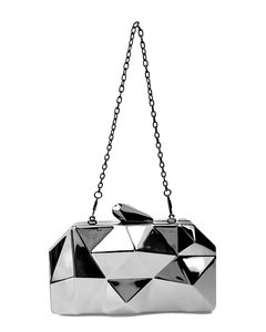 Close-up of silver geometric acrylic evening clutch featuring faceted mirror surfaces